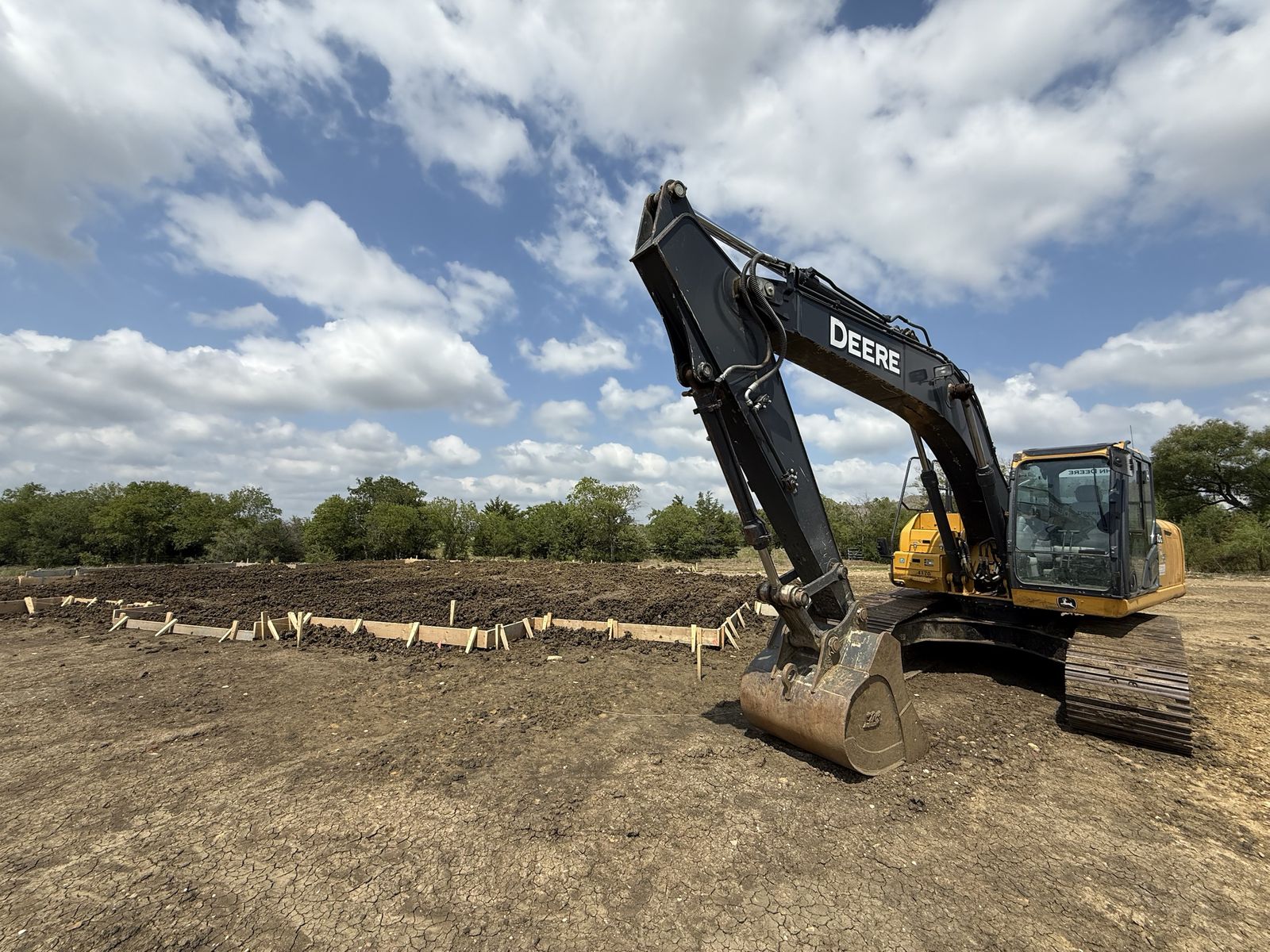Excavator and slab forms on a cleared North Texas homesite